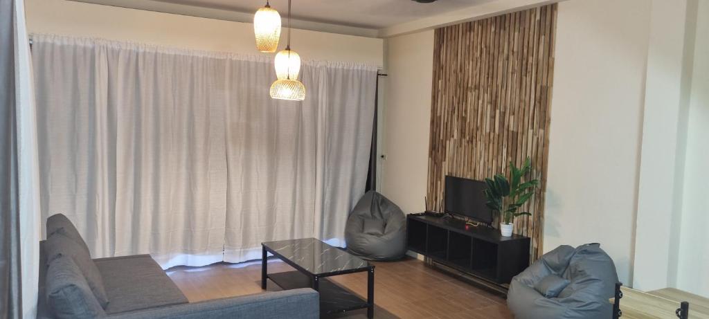 un soggiorno con divano e TV di Khao Jaï Rooms a Thong Sala