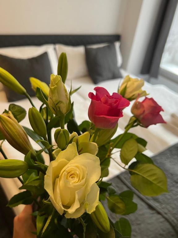 a bouquet of roses in a vase on a bed at Hotel Boston in Karlovy Vary