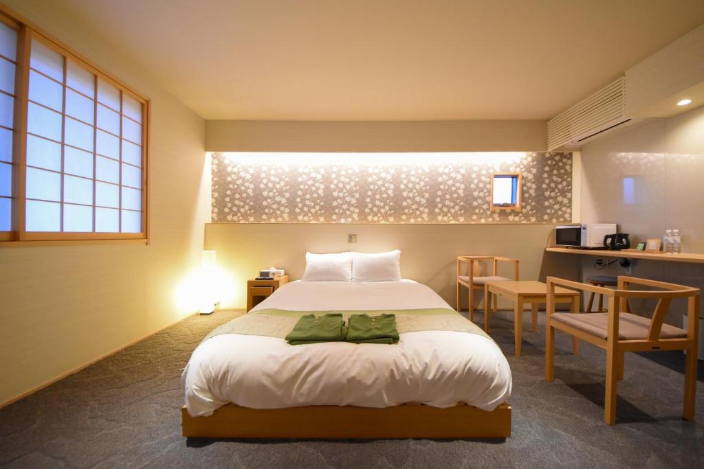 1 dormitorio con 1 cama, mesa y sillas en Hotel Naranohamori, en Nara