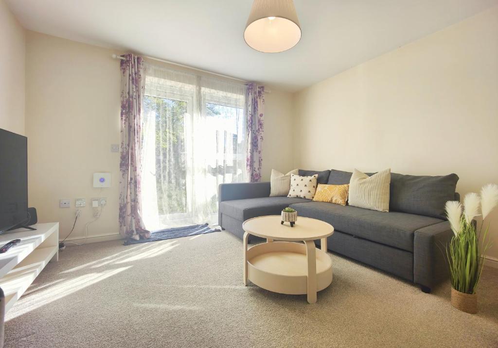 a living room with a blue couch and a table at The Bushmoor - Spacious Holiday Townhouse 10 Minutes to City Centre Free Parking in Manchester