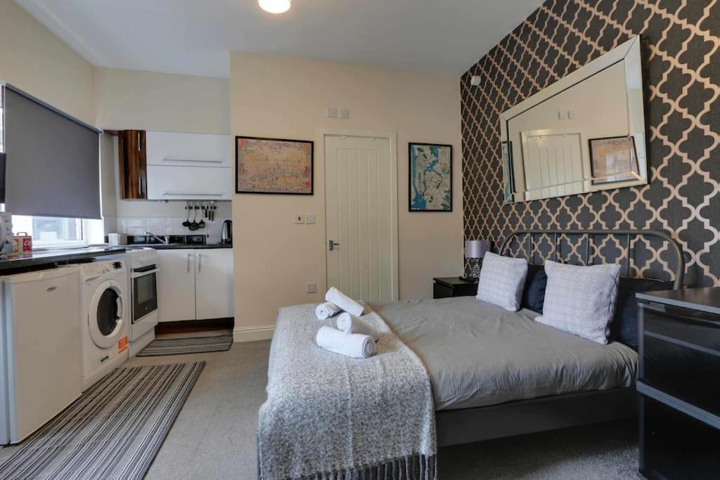 1 dormitorio pequeño con 1 cama y cocina en Modern Studio Apartment - Vibrant Abbeydale Rd, FREE Parking, Pet Friendly, Netflix, en Sheffield