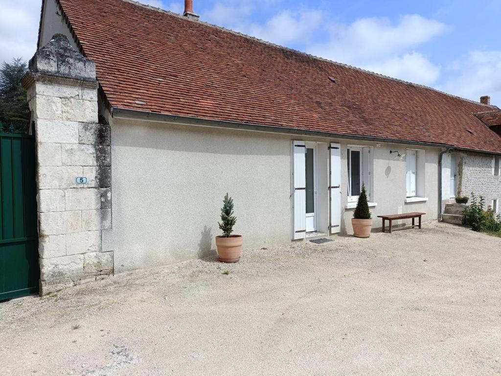 een klein wit huis met een bankje ervoor bij Maison de campagne 4 personnes proche de Loches in Chambourg-sur-Indre