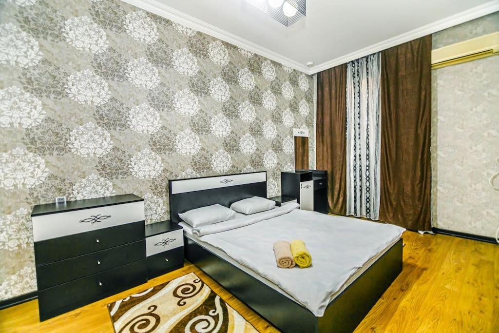 1 dormitorio con 1 cama con 2 zapatillas en Apartment Armani Lux en Bakú