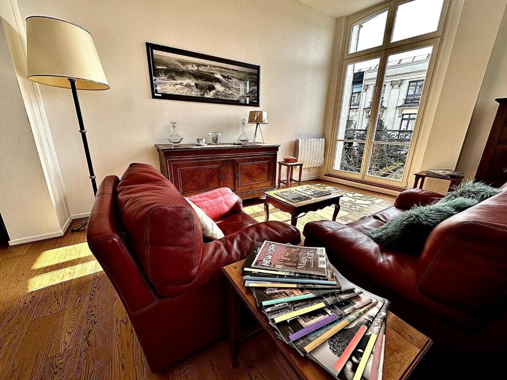 - un salon avec deux fauteuils en cuir et une table dans l'établissement Le Grand Rockefeller Parvis de la Cathédrale de Reims, à Reims