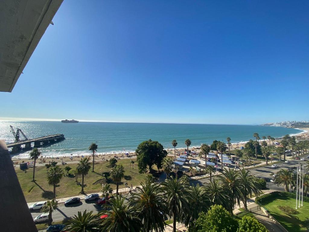 vistas a una playa con palmeras y al océano en Departamento excelente ubicación frente a playa, en Viña del Mar