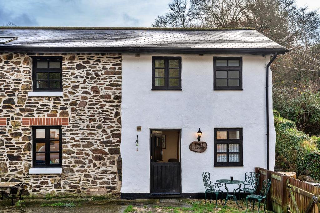 een stenen huis met een tafel ervoor bij Finest Retreats - The Lodge at The Cridford Inn in Trusham