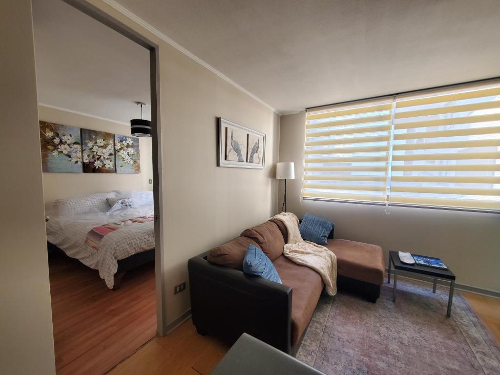 ein Wohnzimmer mit einem Sofa und einem Bett in der Unterkunft Encantador Metro Central in Santiago