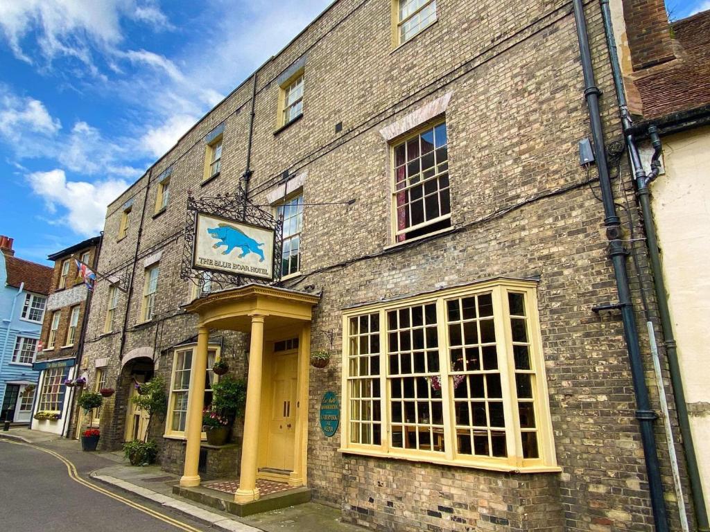 un edificio di mattoni con un cartello blu per cavalli di Blue Boar Hotel a Maldon