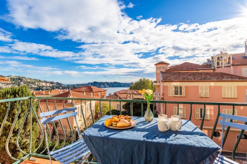 a table with a plate of fruit on a balcony at LE PROVENCAL AP4389 By Riviera Holiday Homes in Villefranche-sur-Mer