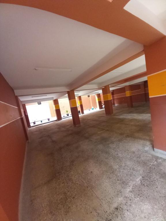 uma sala vazia com paredes laranja e pilares amarelos em THE G2 em Nakuru