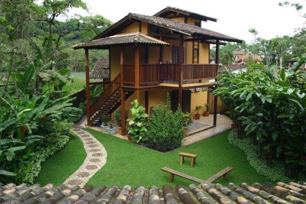 uma pequena casa com uma varanda num quintal em QUINTAL DA MATA em São Sebastião