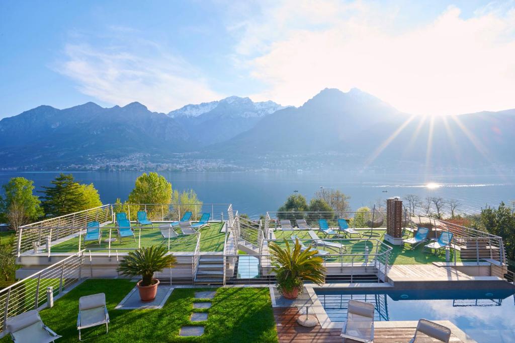 een huis met uitzicht op een meer en de bergen bij Bellagio Village- 4 Apartments by the lake - Seasonal Warm Pool and Sauna in Oliveto Lario