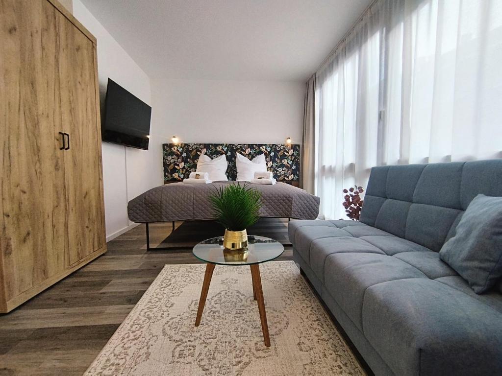 een woonkamer met een bank en een bed bij Design-Apartmenthaus für bis zu 12, modern, Dachterrasse, Grill, ruhige Lage, Disney plus, Wii, LAN und WLAN in Neurenberg