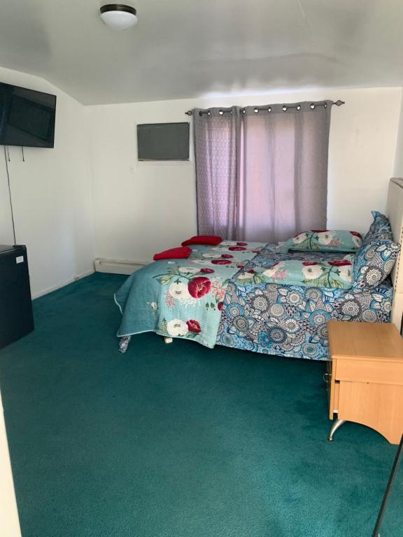 a bedroom with a bed and green carpet at Bangaly Guest House Newyork in Locust Manor