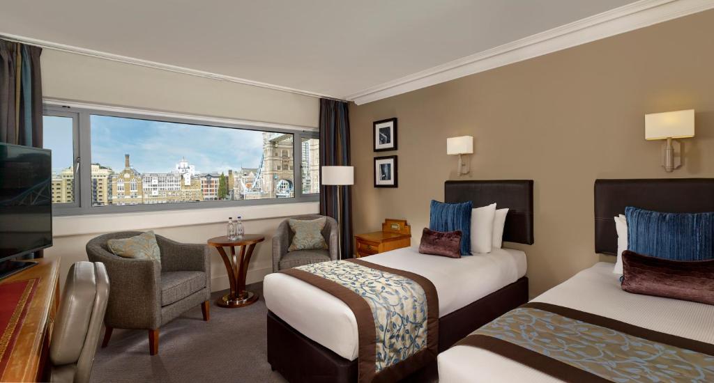 a hotel room with two beds and a window at The Tower Hotel, by Thistle in London