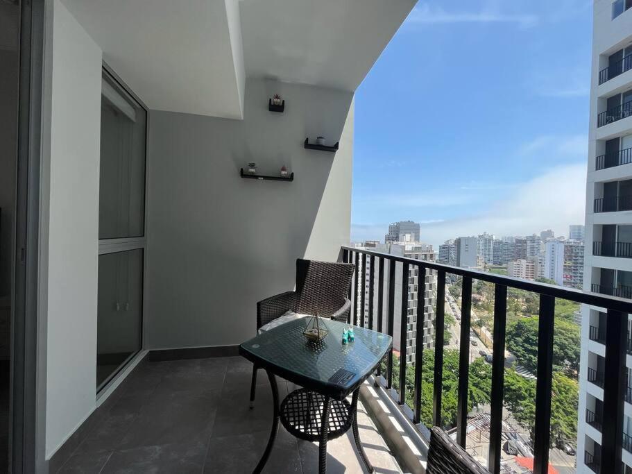 a balcony with a table and a view of a city at Barranco Piso 18 Vista al mar piscina Jacuzzi gym in Lima