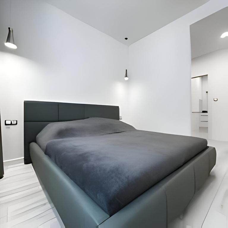 um quarto com uma cama grande num quarto branco em New cool stylish apartment em Bratislava