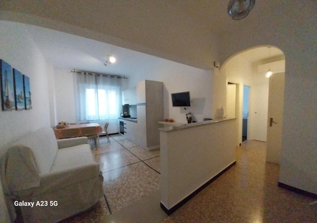 a white living room with a couch and a television at A casa di Anna in Finale Ligure