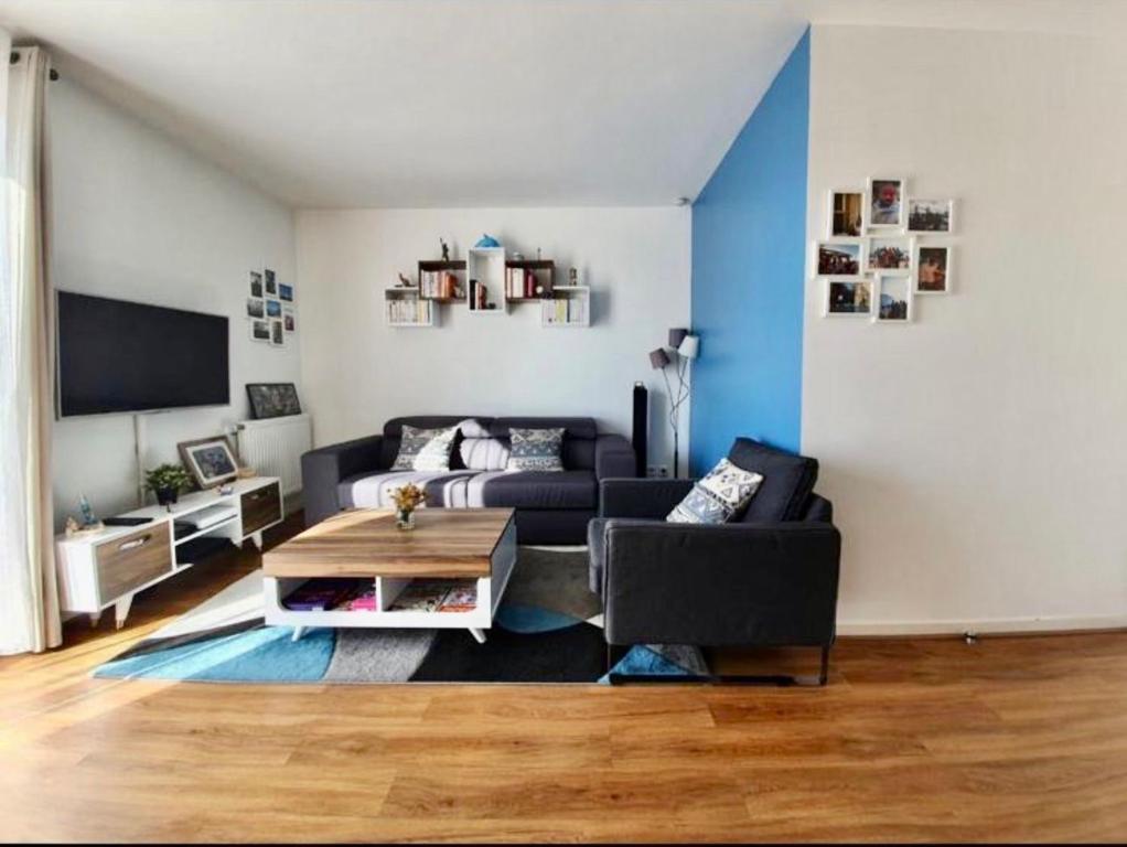 ein Wohnzimmer mit einem Sofa und einem Tisch in der Unterkunft Nanterre home in Nanterre