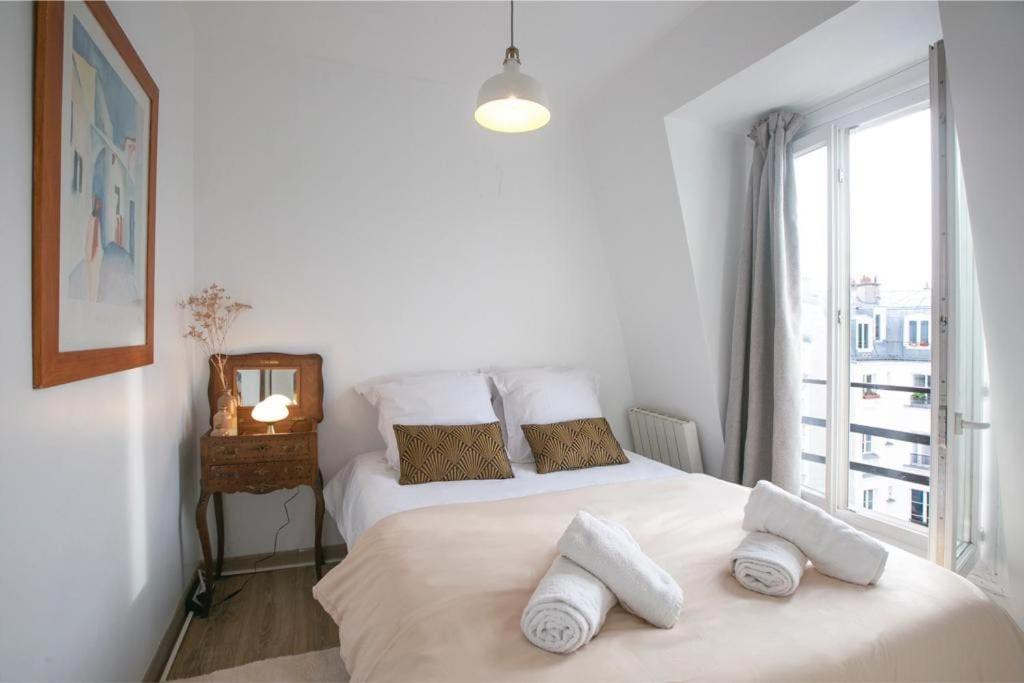 - une chambre avec 2 lits avec des oreillers et une fenêtre dans l'établissement Heavenly & Cozy Parisian Flat - Place Voltaire, à Paris