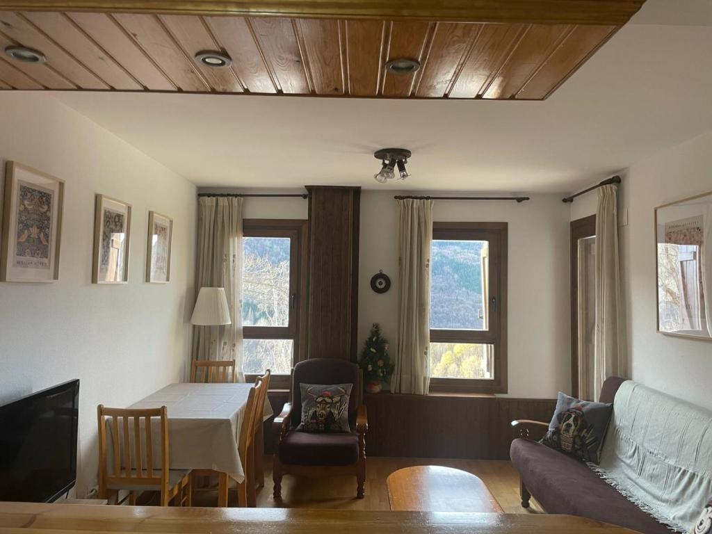 a living room with a table and a couch at Cerler- Aigualluts-Pirineo en familia in Cerler