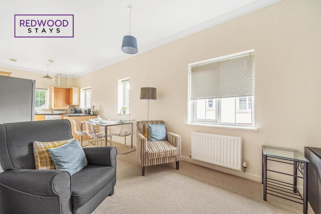 a living room with a chair and a kitchen at 2 Bedroom Apartment, Business & Contractors, FREE Parking & Netflix By REDWOOD STAYS in Basingstoke