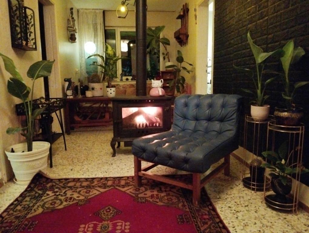 a living room with a chair and a fireplace at Garden Village Home in Ayvalık