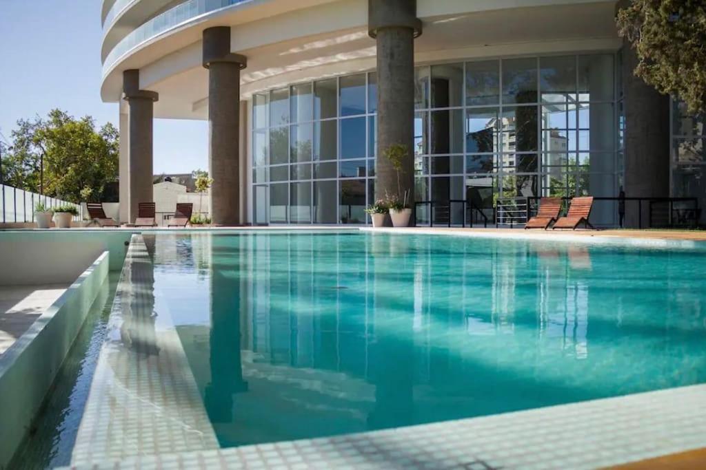 una piscina frente a un edificio en Excelente Depto Torre Leloir by Inside en Villa Marini