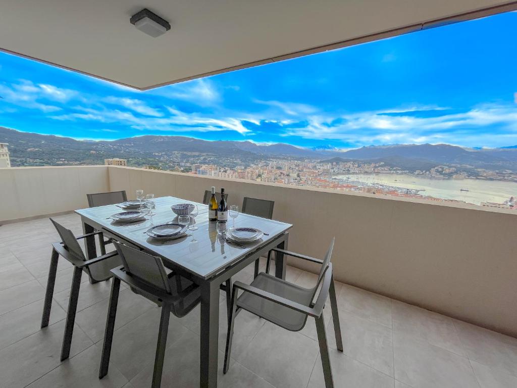 - une salle à manger avec une table et des chaises offrant une vue dans l'établissement Les terrasses de Toretta, à Ajaccio