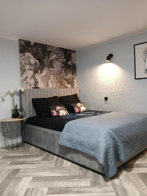 1 dormitorio con 1 cama y una pared con flores en Pod Kasztanami blisko A2, 