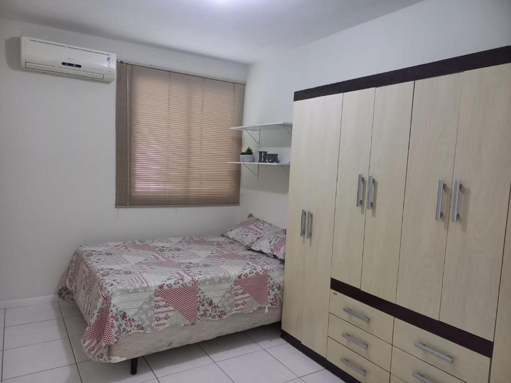 Dormitorio pequeño con cama y vestidor en Apto de dois quartos com uma suíte, en Palhoça