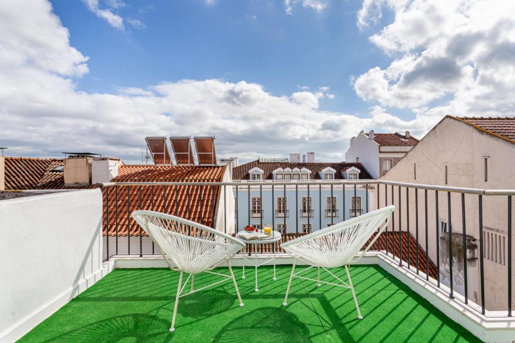a balcony with two chairs and a table on a roof at Lapa Duplex Apartment in Lisbon
