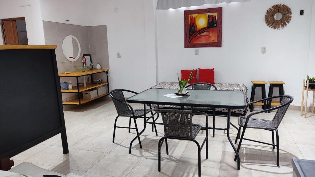 een eetkamer met een glazen tafel en stoelen bij Departamento temporario Banda para 4 personas a 5 min del estadio madre de ciudades y del nodo tecnologico in La Banda