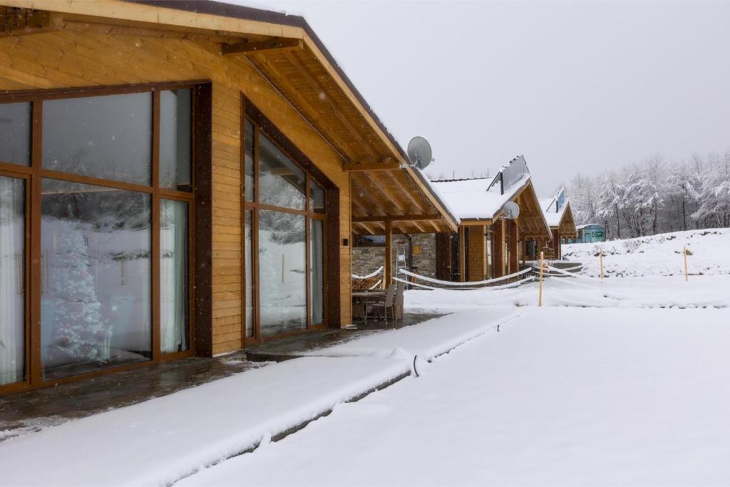 a building with snow on the ground in front of it at Villa Sofayla in Bansko