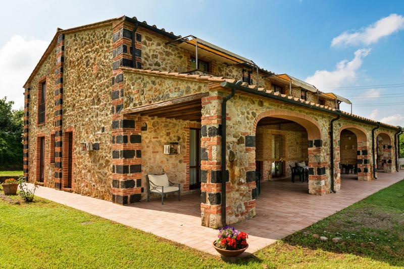 a large brick building with a large patio at Podere Cascatelle&Agriletizia - Cascate Naturali in Massa Marittima