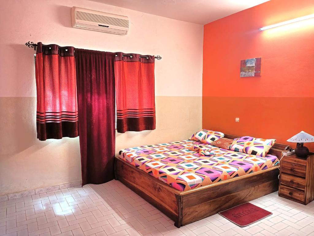 a bedroom with a bed and red curtains at Cloud9 Lomé in Lomé