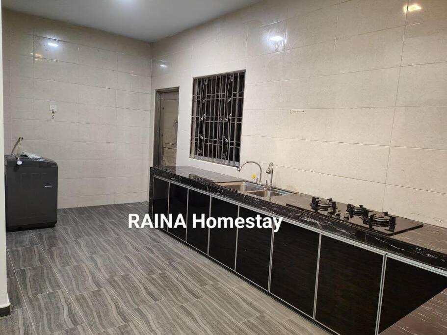 ein Badezimmer mit einem Waschbecken und einer Theke in der Unterkunft three bedroom tarraced house - RainaHomestay Pasir Gudang in Pasir Gudang
