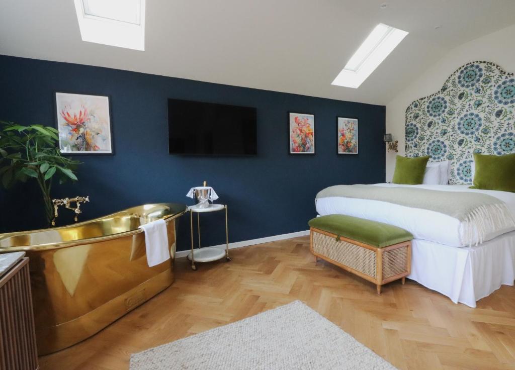 1 dormitorio con bañera, 1 cama y TV en The Pear Tree Inn en Bury Saint Edmunds