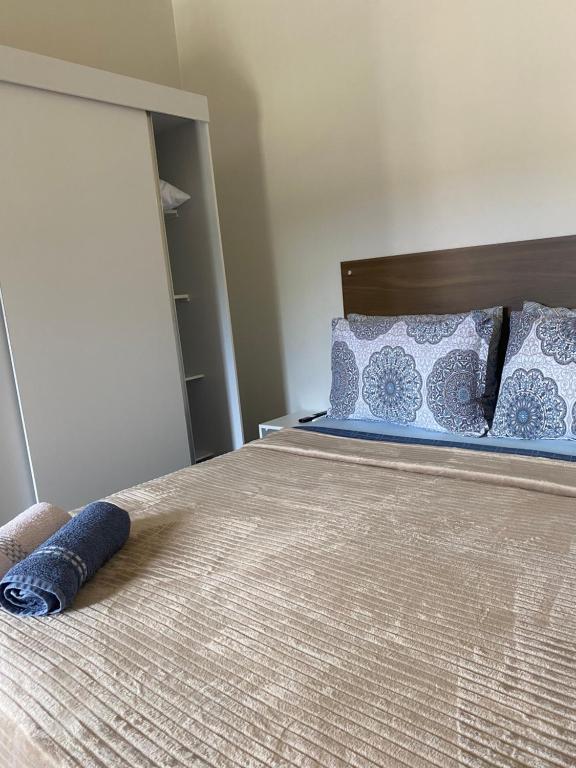 a bedroom with a bed with blue pillows at Apartamento encantador cachoeira in Florianópolis