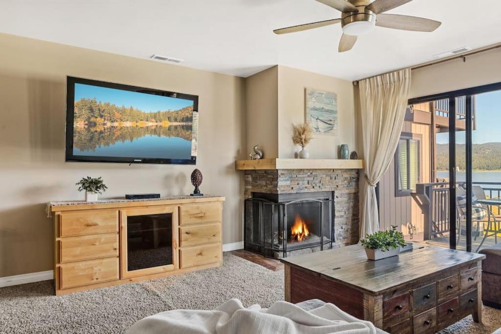 a living room with a fireplace and a flat screen tv at Lakefront at the Village in Big Bear Lake