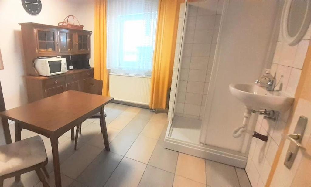 a small kitchen with a table and a sink and a bathroom at Villa Fortuna Natur in Lackenhof