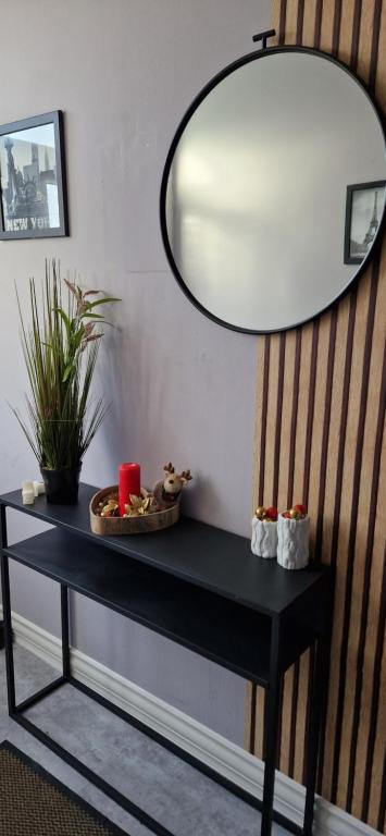 une table noire avec un miroir sur un mur dans l'établissement Pension STELLA, à Lutherstadt Eisleben