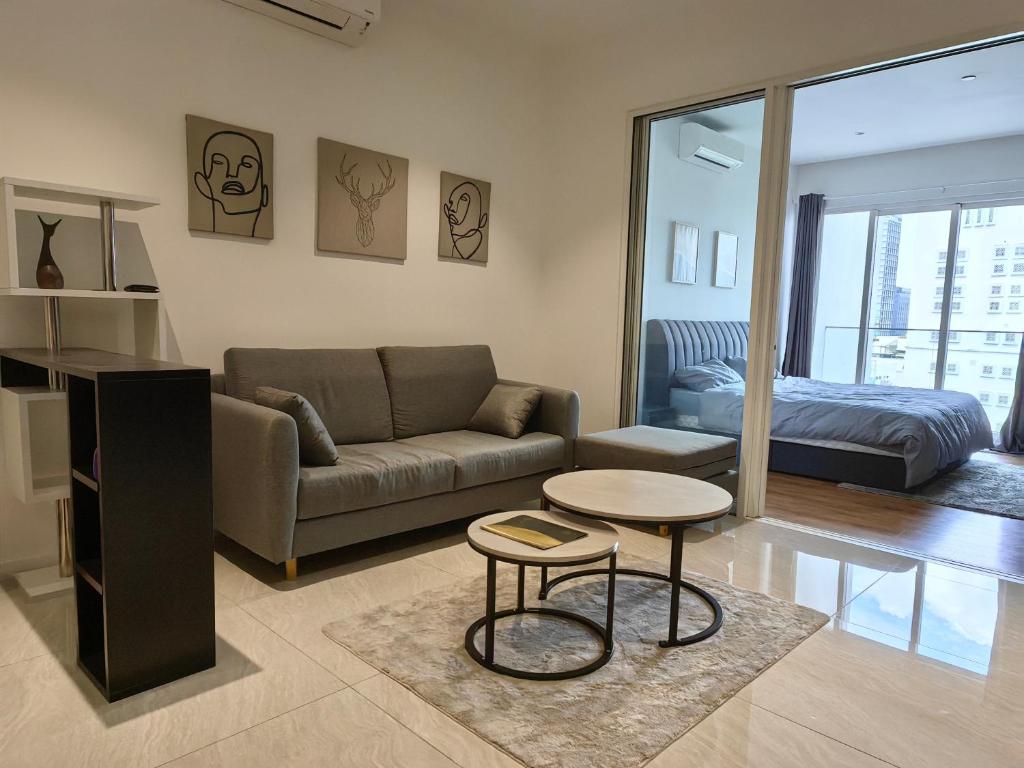 a living room with a couch and a table and a bed at Quill Residences Suites Kuala Lumpur in Kuala Lumpur