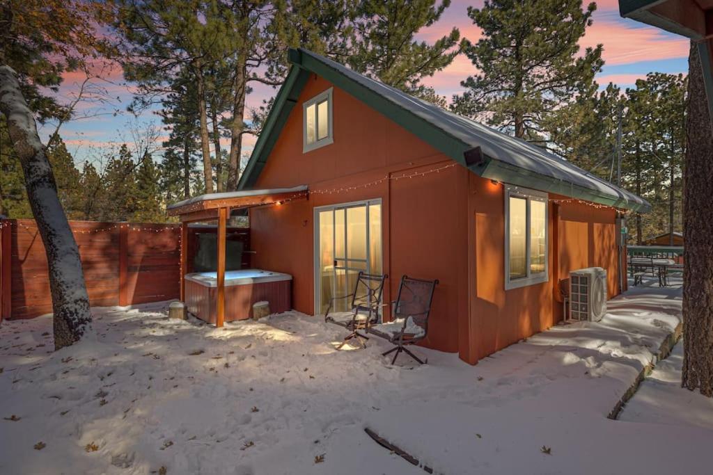 una pequeña casa roja con un patio cubierto de nieve en Calipe Cottage, en Sugarloaf