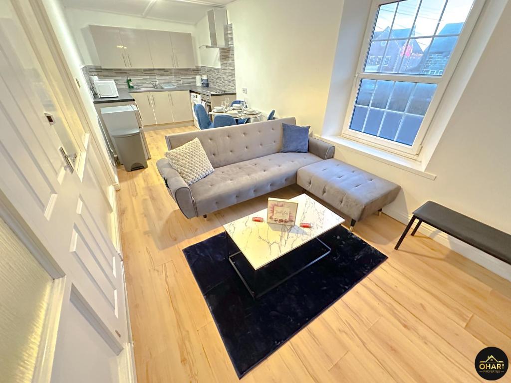 a living room with a couch and a table at Modern 2 Bed Apartment - FREE Parking - Contractors in Morpeth