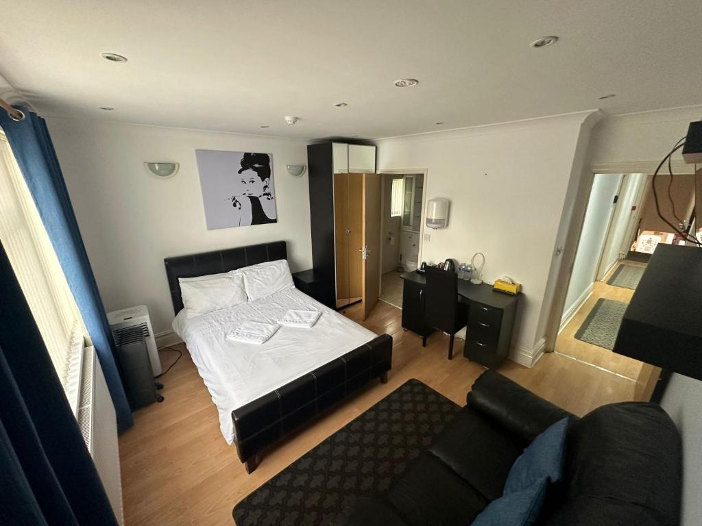 a small bedroom with a bed and a couch at 3 Luxury En-suite Bedrooms in Cardiff
