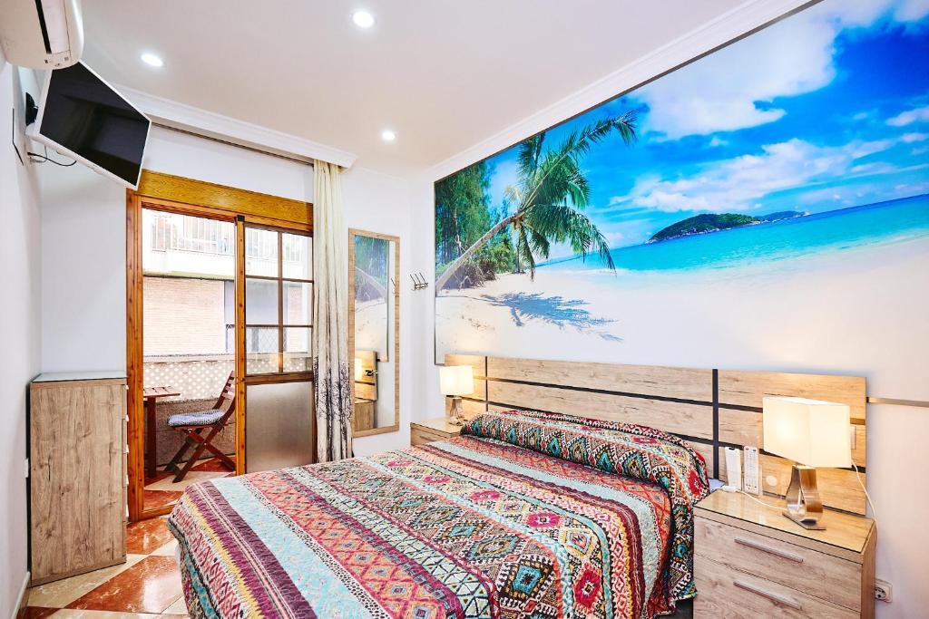 ein Schlafzimmer mit einem Bett und einem Gemälde eines Strandes in der Unterkunft Holidays Beach Torrox - 4 in Morche