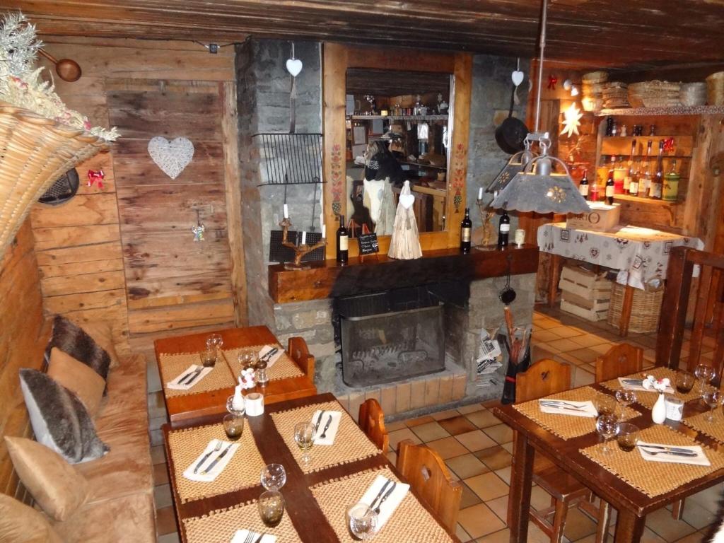 a dining room with wooden tables and a fireplace at La Bournerie in Le Grand-Bornand