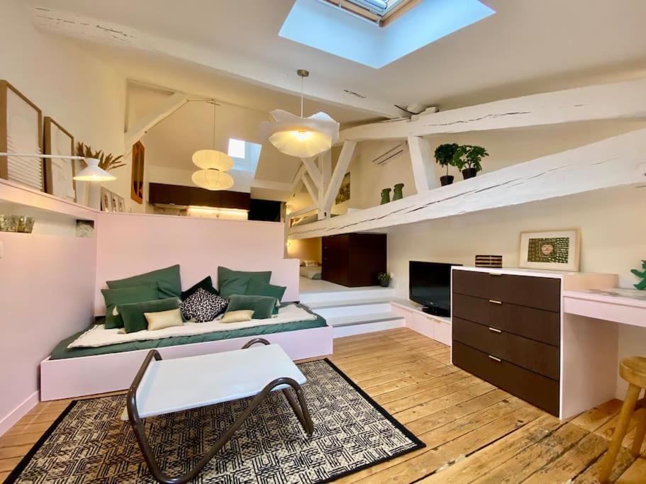 duży salon z łóżkiem i kanapą w obiekcie Charmant cocon sous les toits de Bordeaux w mieście Bordeaux