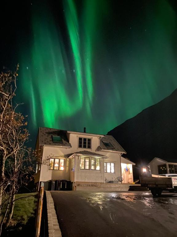 a house with the aurora in the sky at Dyr tillatt i vakkert hus med naturomgivelser i Lofoten in Sennesvik